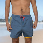 Man standing wearing mens swimwear. Front view showing phone pocket and inner liner.