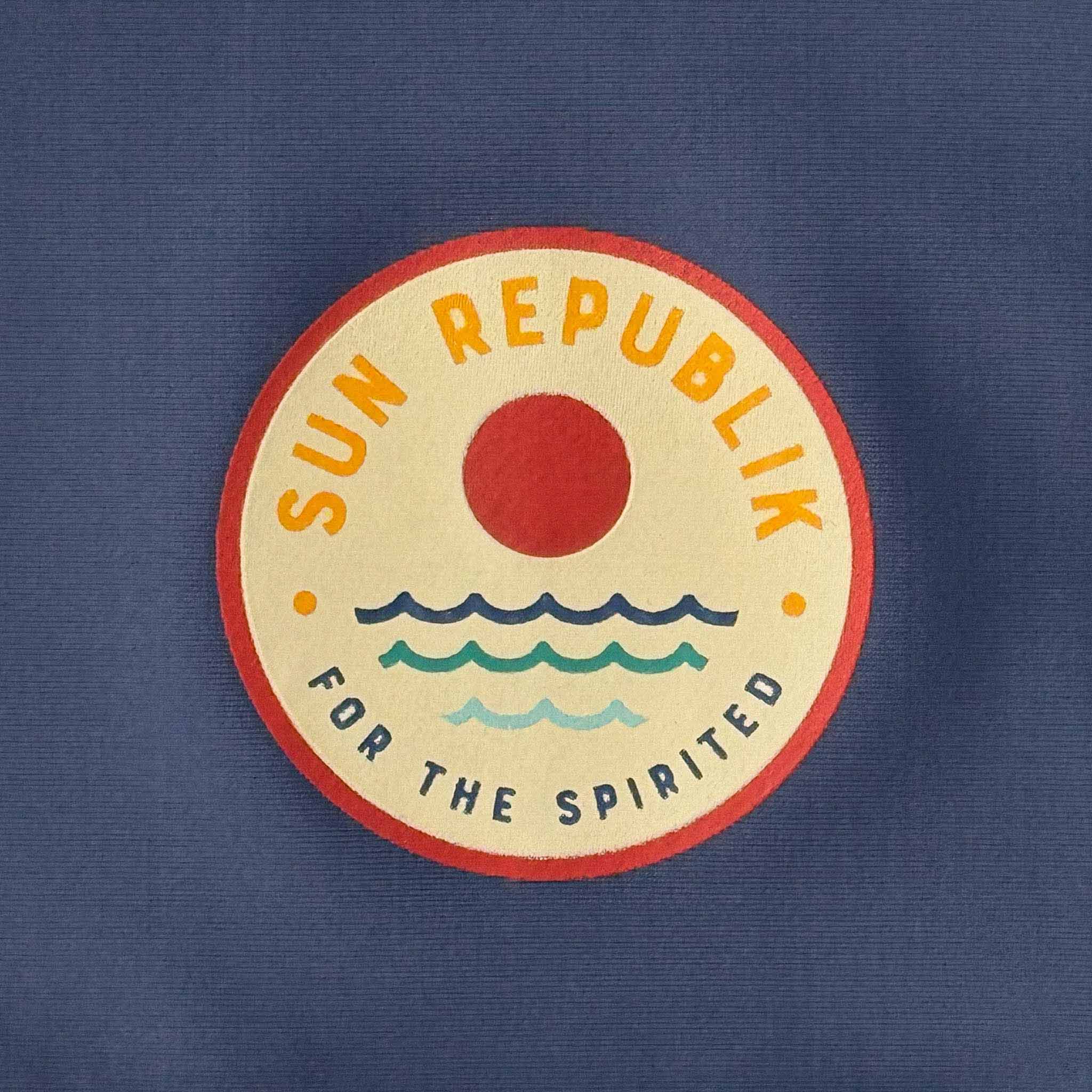 Close cropped view of sun republik logp on men swimwear rash guard.
