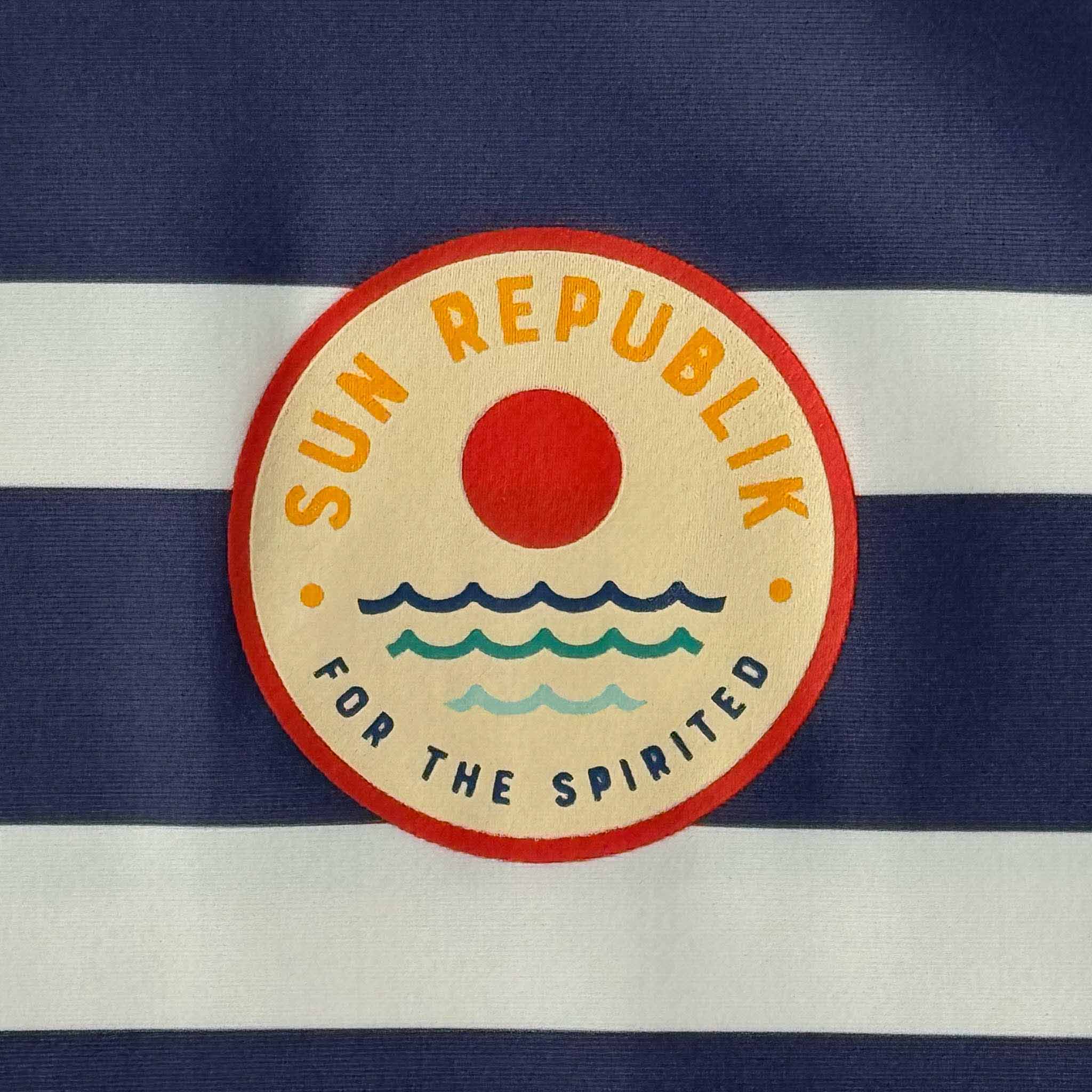all-products Close cropped view of mens beach wear swim top wiih sun republik logo.