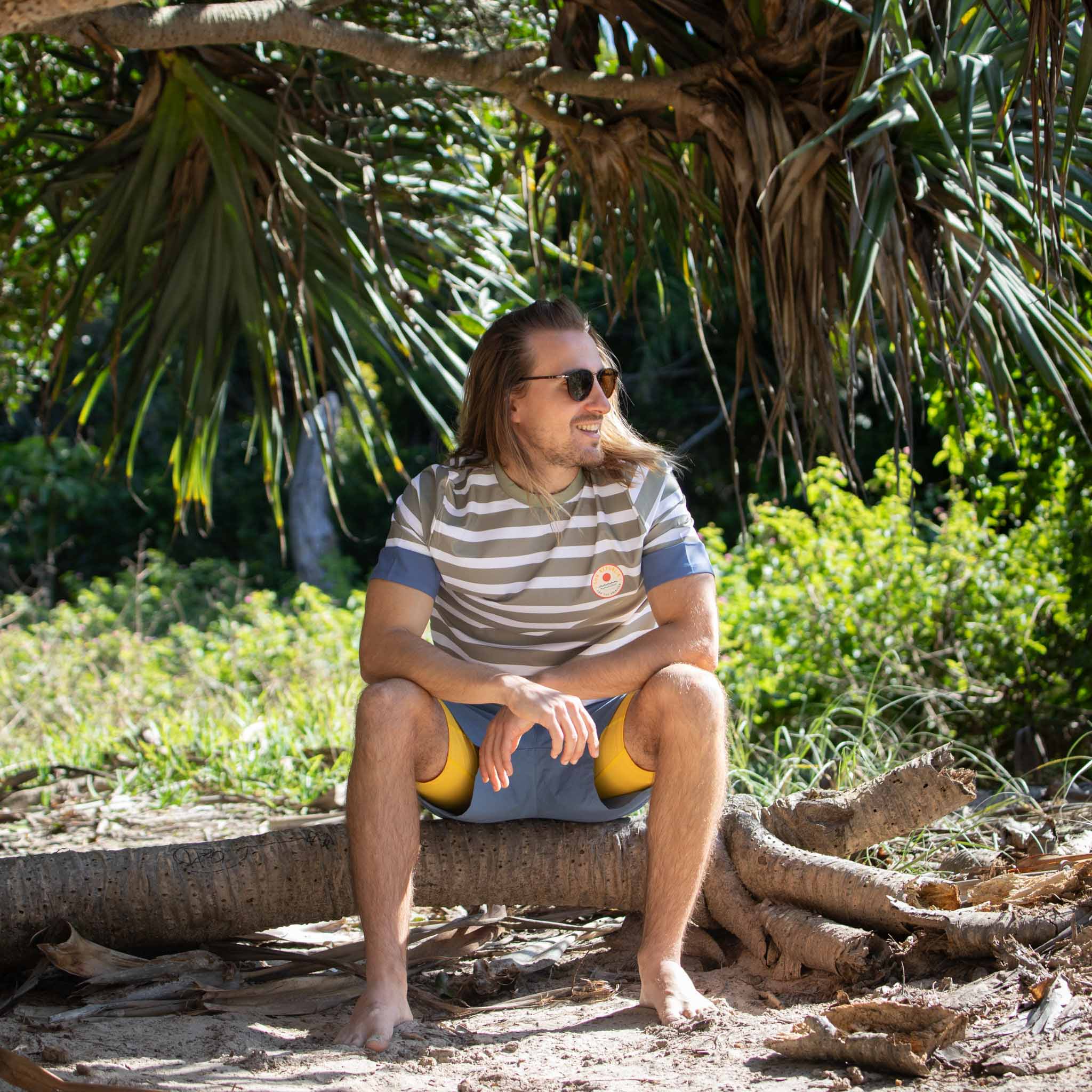 Men sat outside wearing mens beach wear swim top and shorts with inner liner.