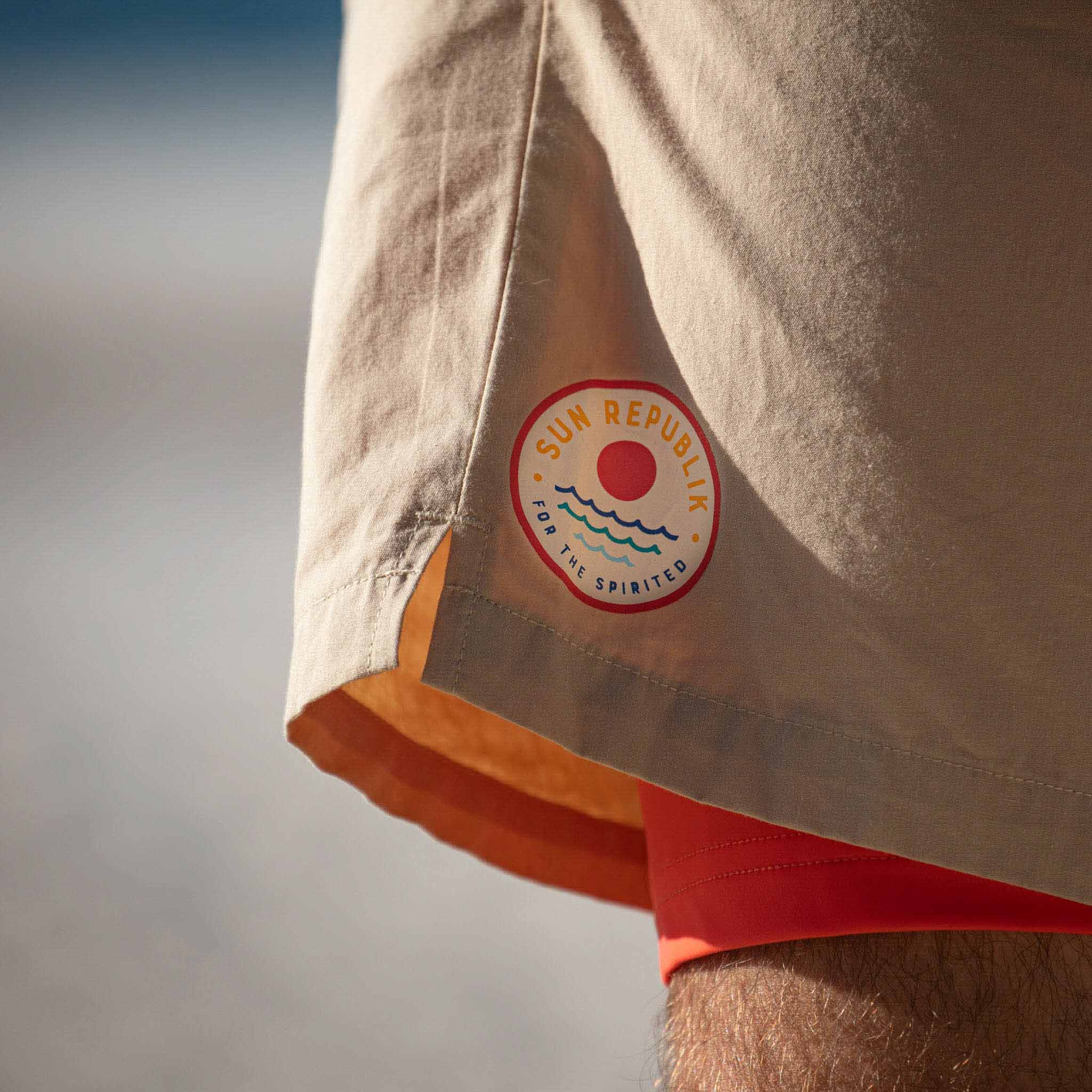 all-groups Close cropped view of mens swim with red inner liner and sun republik logo.