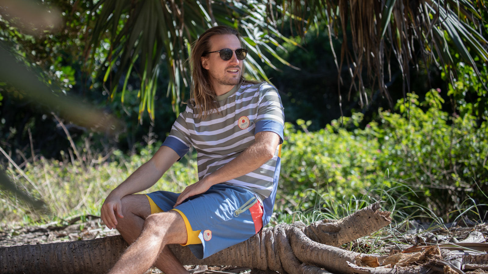 man sat on log wearing mens beach shorts