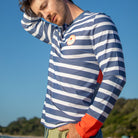 Man wearing men swimwear, swim shirt with long sleeves. Sky background. 